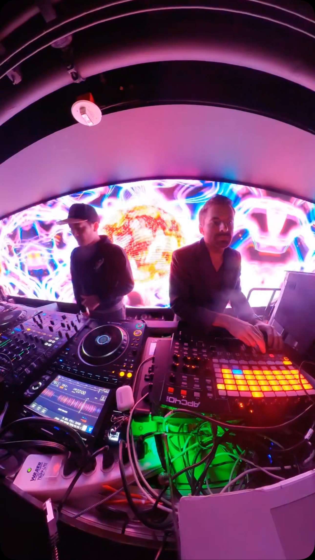 OpticMystic performing at Troy Liquor Bar DJ booth with vibrant visuals